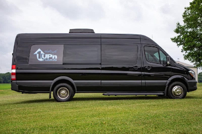 Ford F-550 Limo Bus Black limousine van with 1Up'n Limousines logo on side.