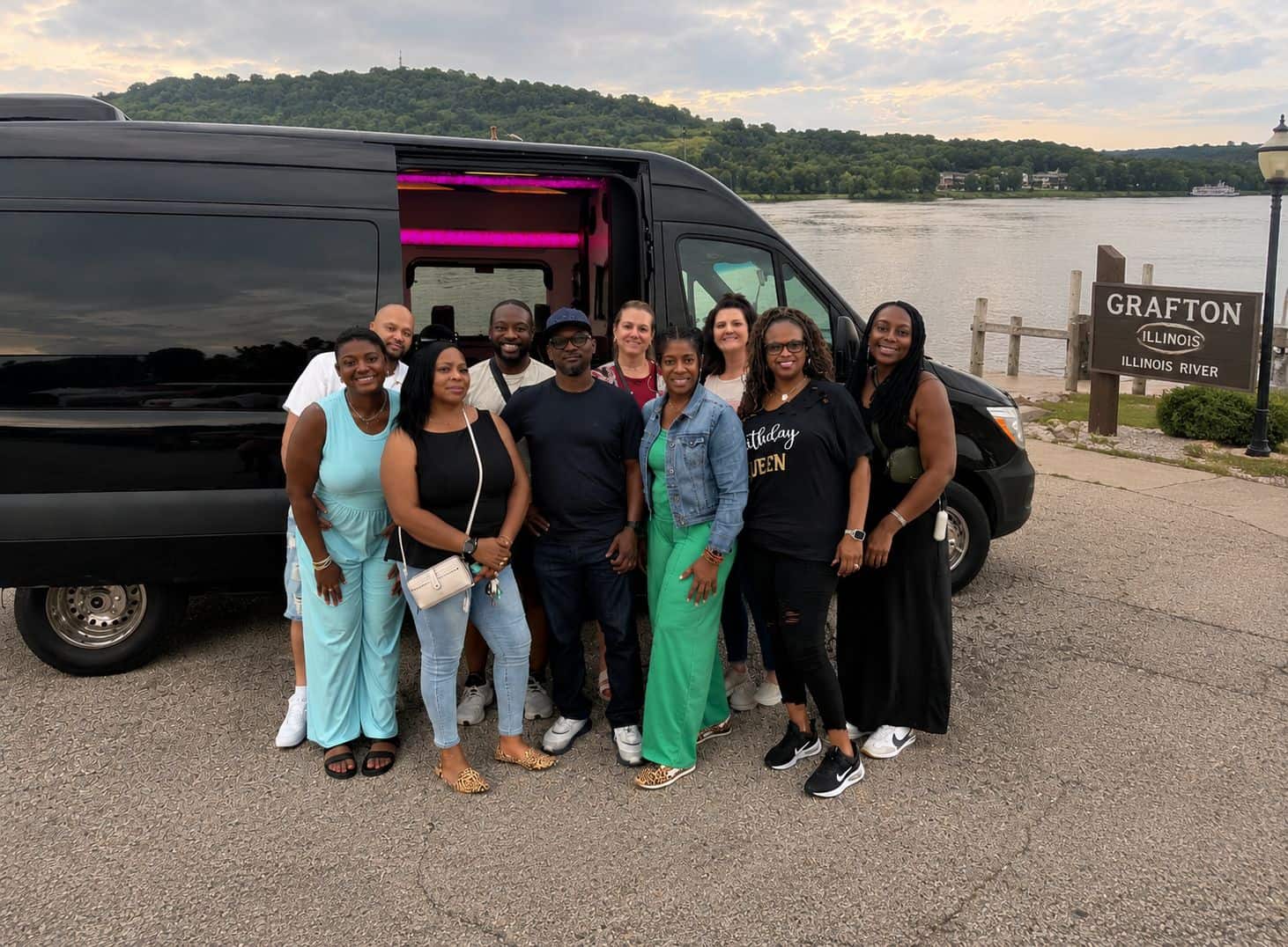 Group of People with Limousine by Illinois River Group of diverse people standing near a black limousine by Illinois River.