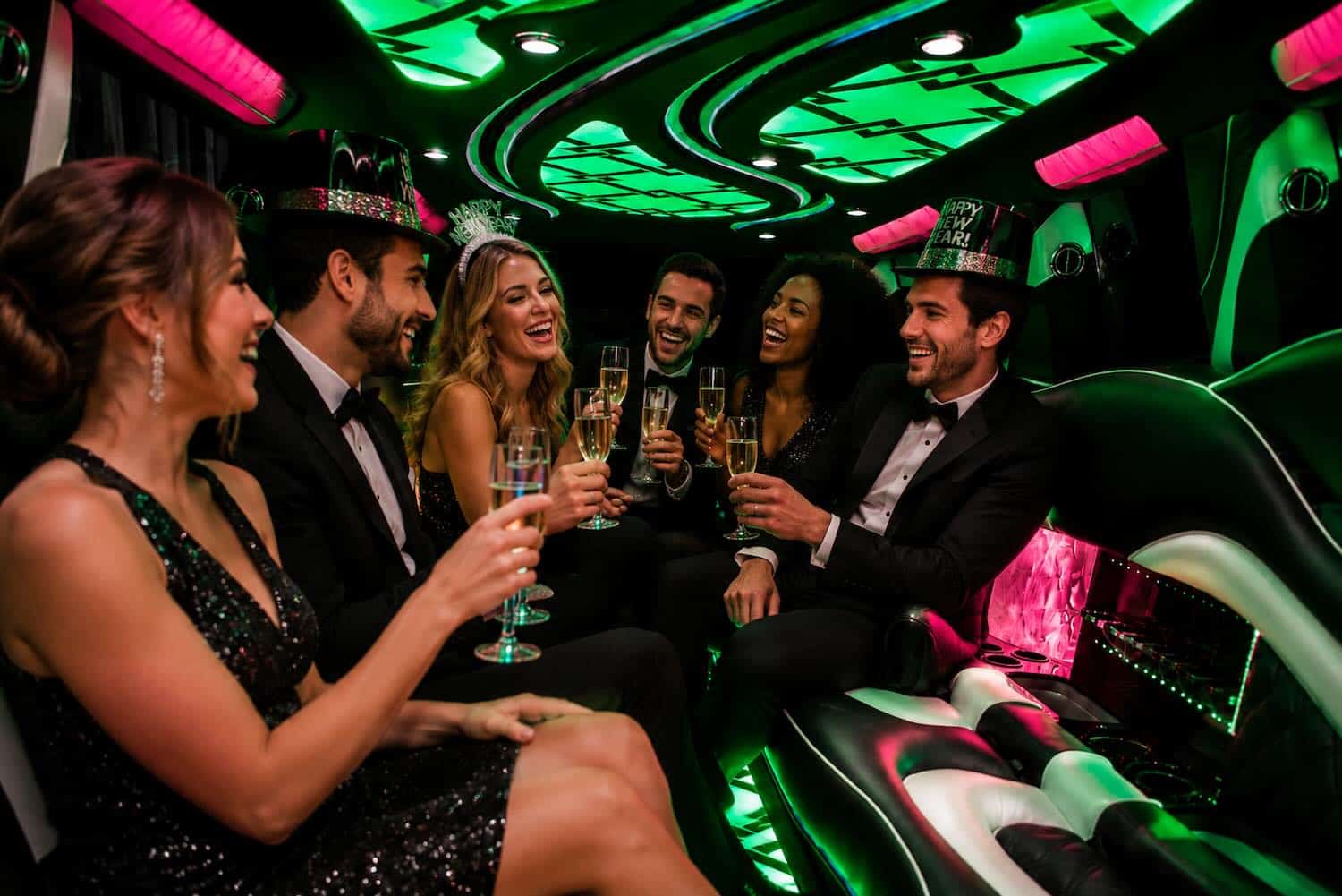 Escalade-New-Years-Eve Luxurious limousine interior with vibrant green and pink neon lighting.