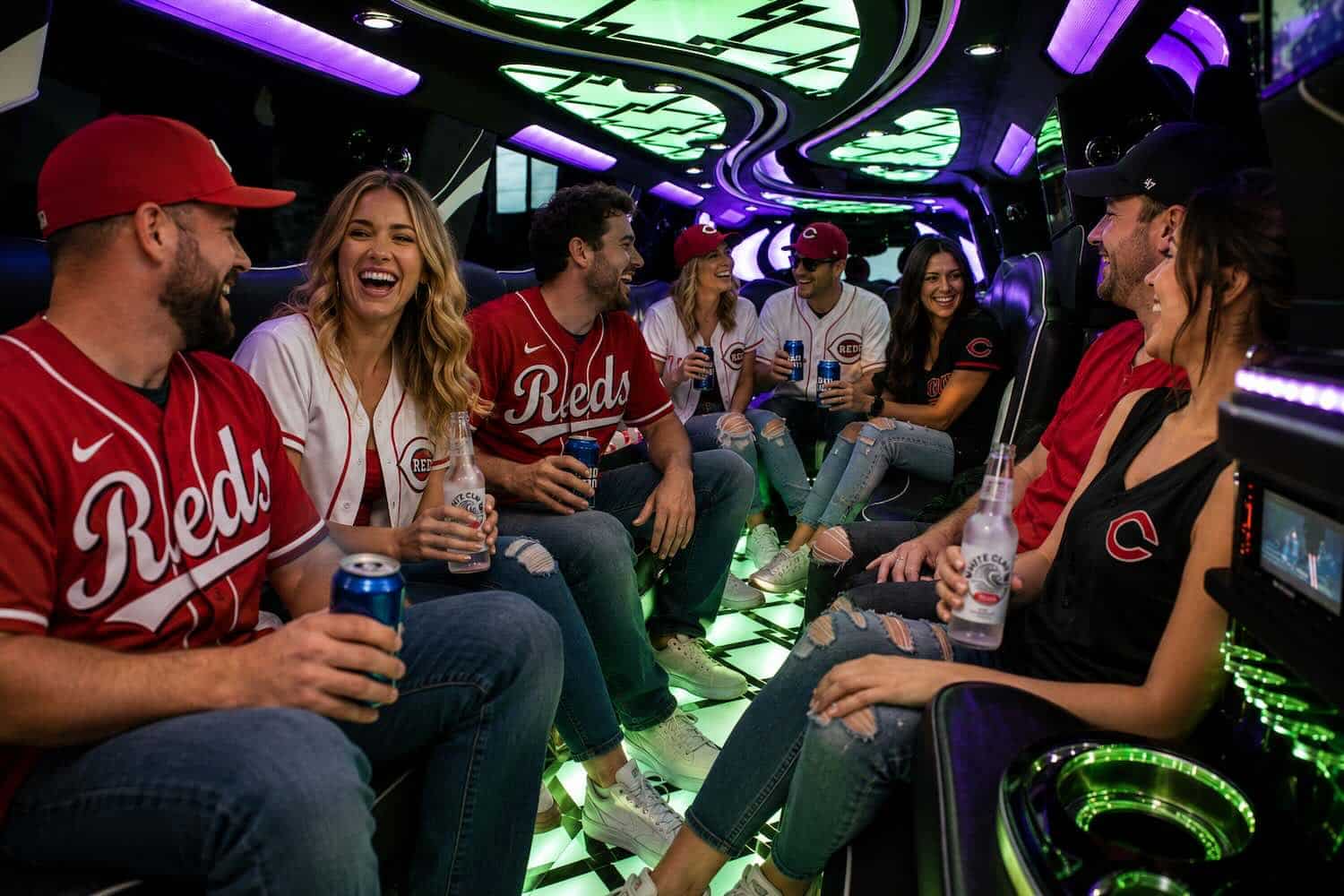 Escalade-Sporting-Event Luxurious limousine interior with neon purple and green lighting and plush seating.